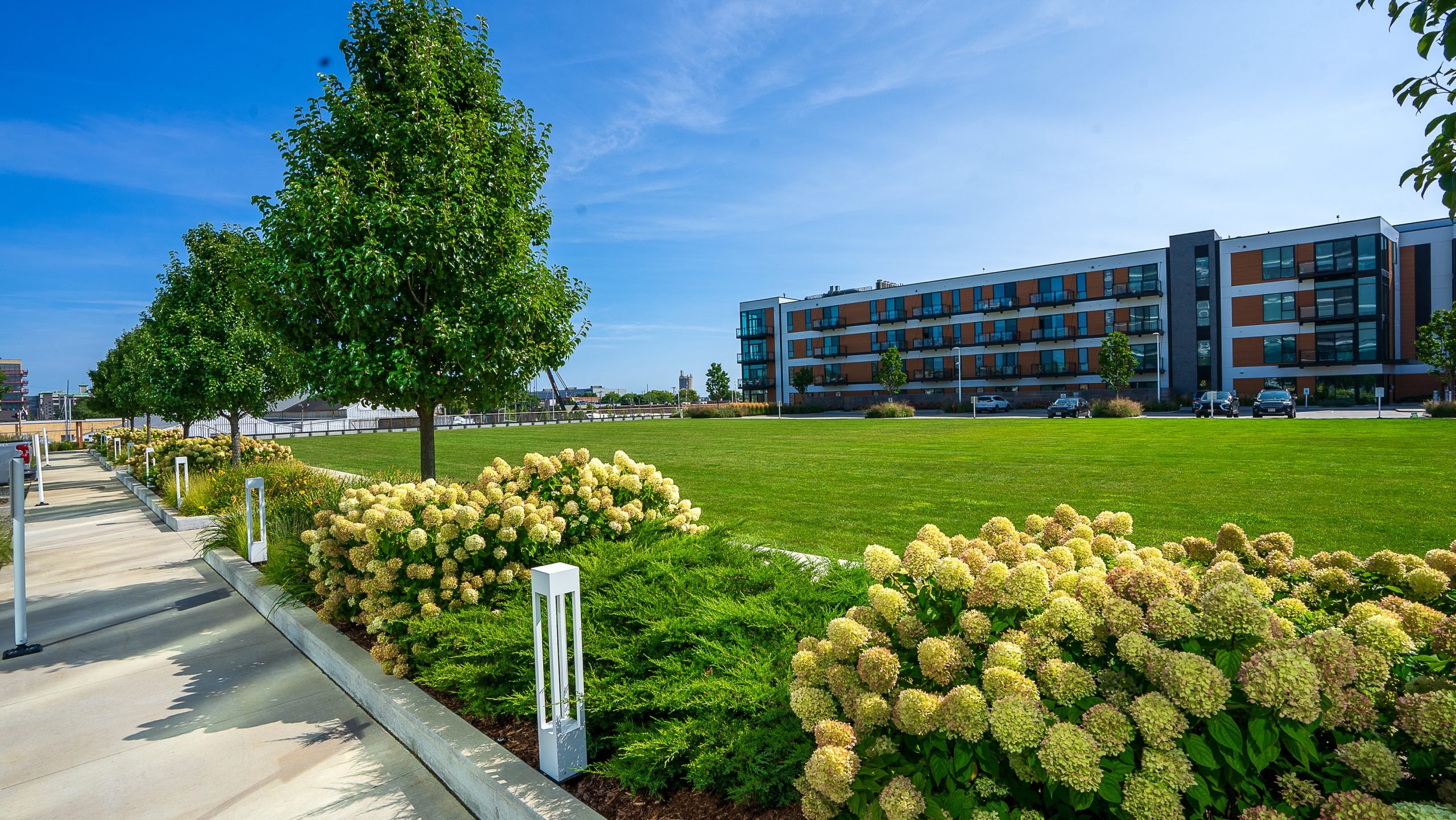 Fall landscape maintenance at R1ver showcasing red pear trees and diverse shrubs